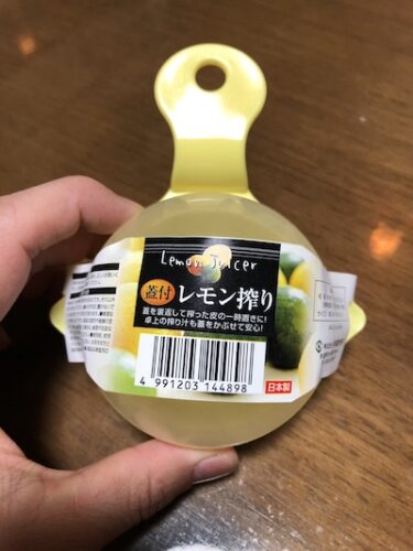 レモン絞り器を持つ